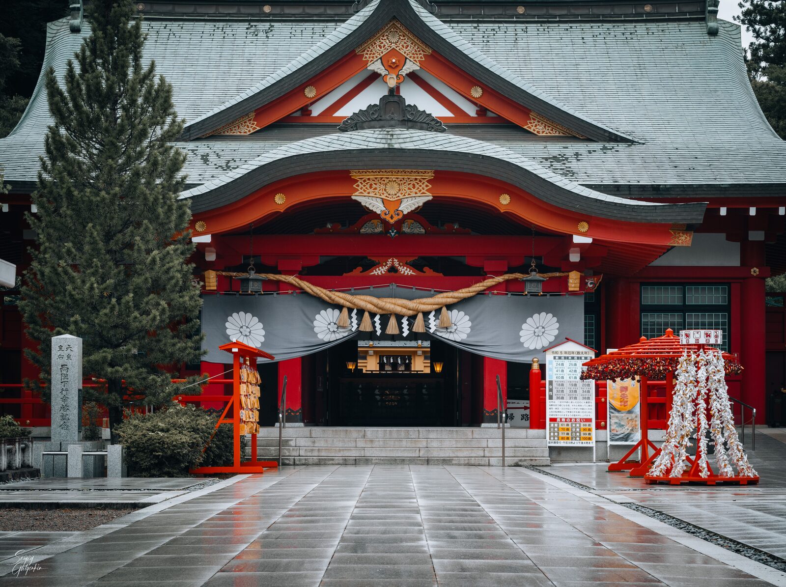 雨に濡れる宮城縣護國神社の拝殿と奉納された千羽鶴