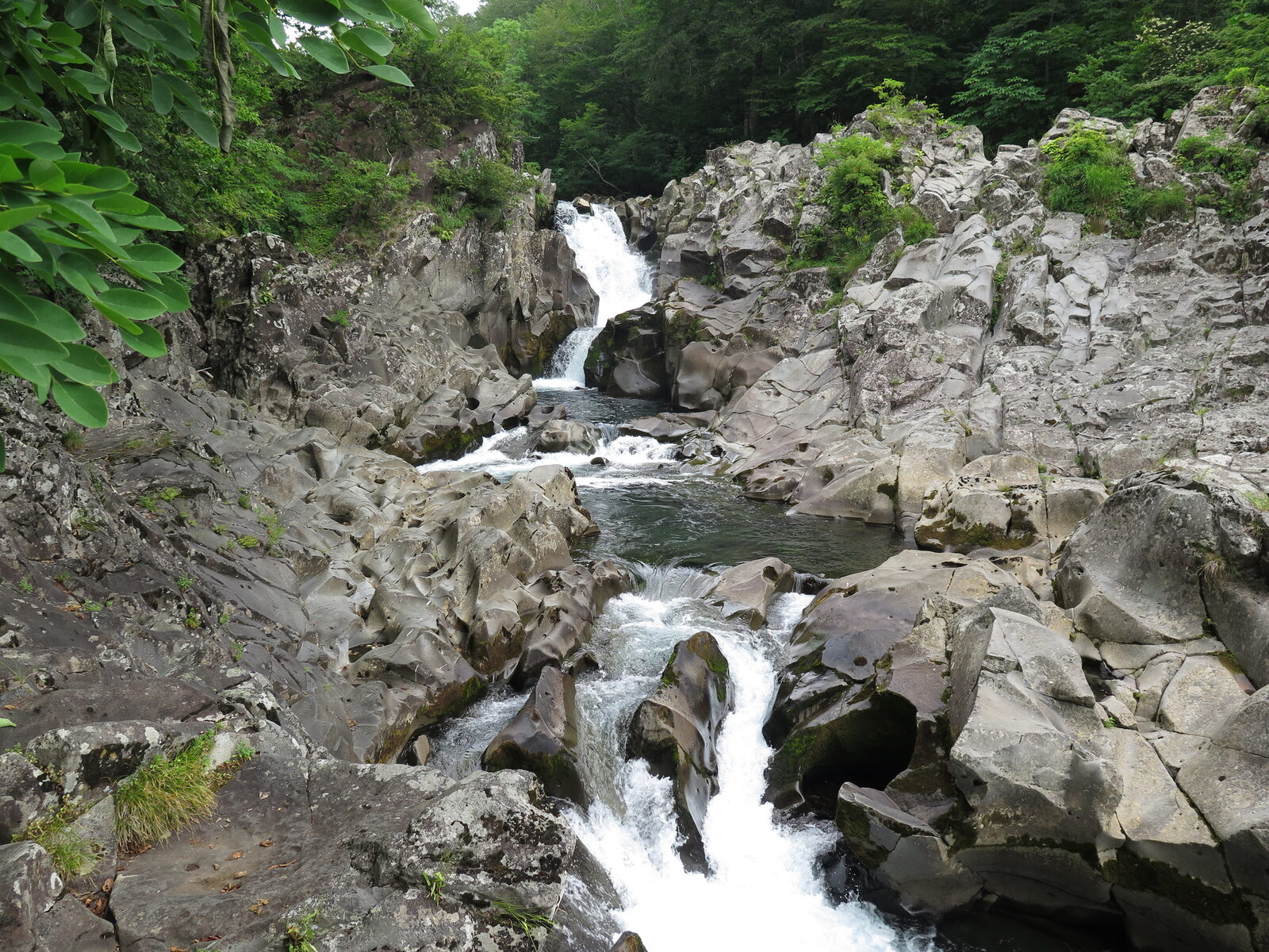 法体の滝の下流、岩肌に刻まれた甌穴群を流れる渓流