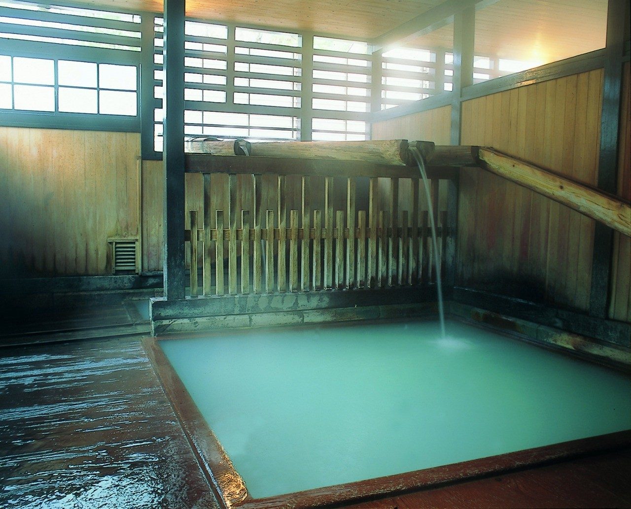 滝の湯の木造浴室に流れ落ちる白濁の湯