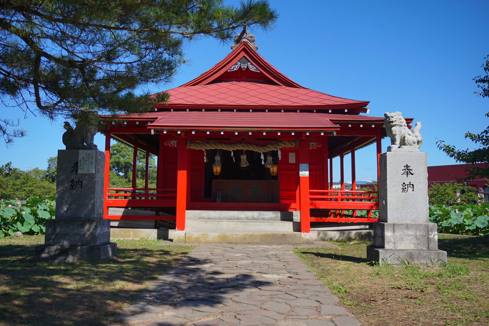 鏡ヶ池の中島に鎮座する赤い社殿の胸肩神社