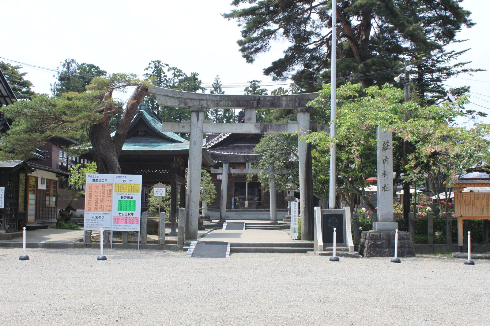 荘内神社の社号標と鳥居、桜の季節の境内