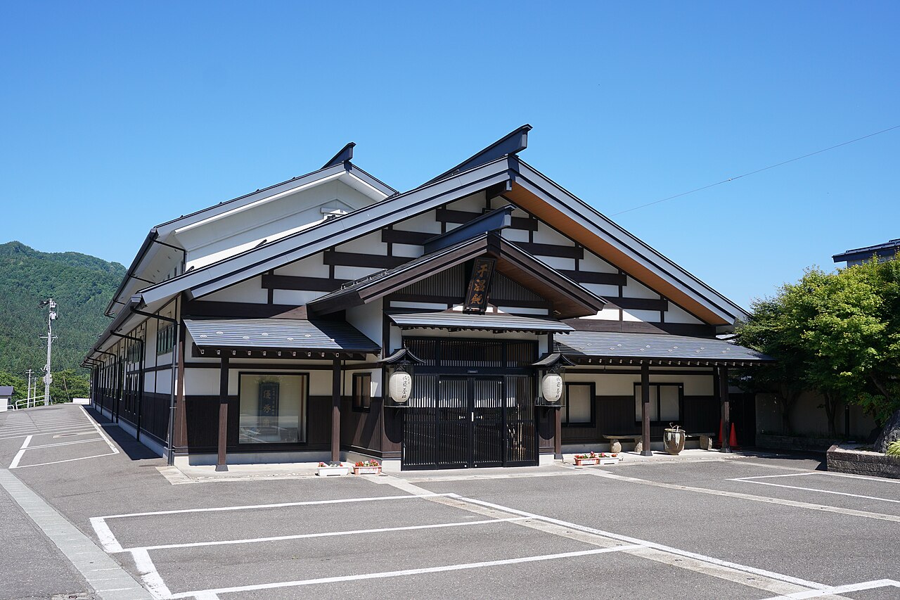 佐藤養助総本店の趣ある店舗建物、青空の下