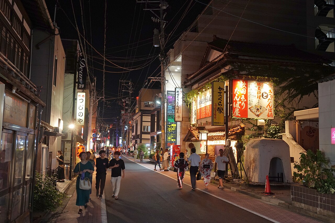 川反の夜の街並み、きりたんぽ鍋の看板と行き交う人々