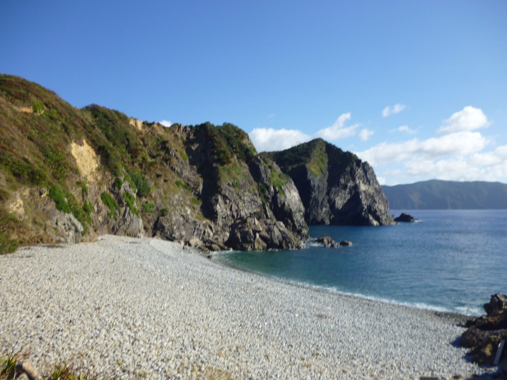 ホノホシ海岸の玉石の浜と、海へせり出す断崖