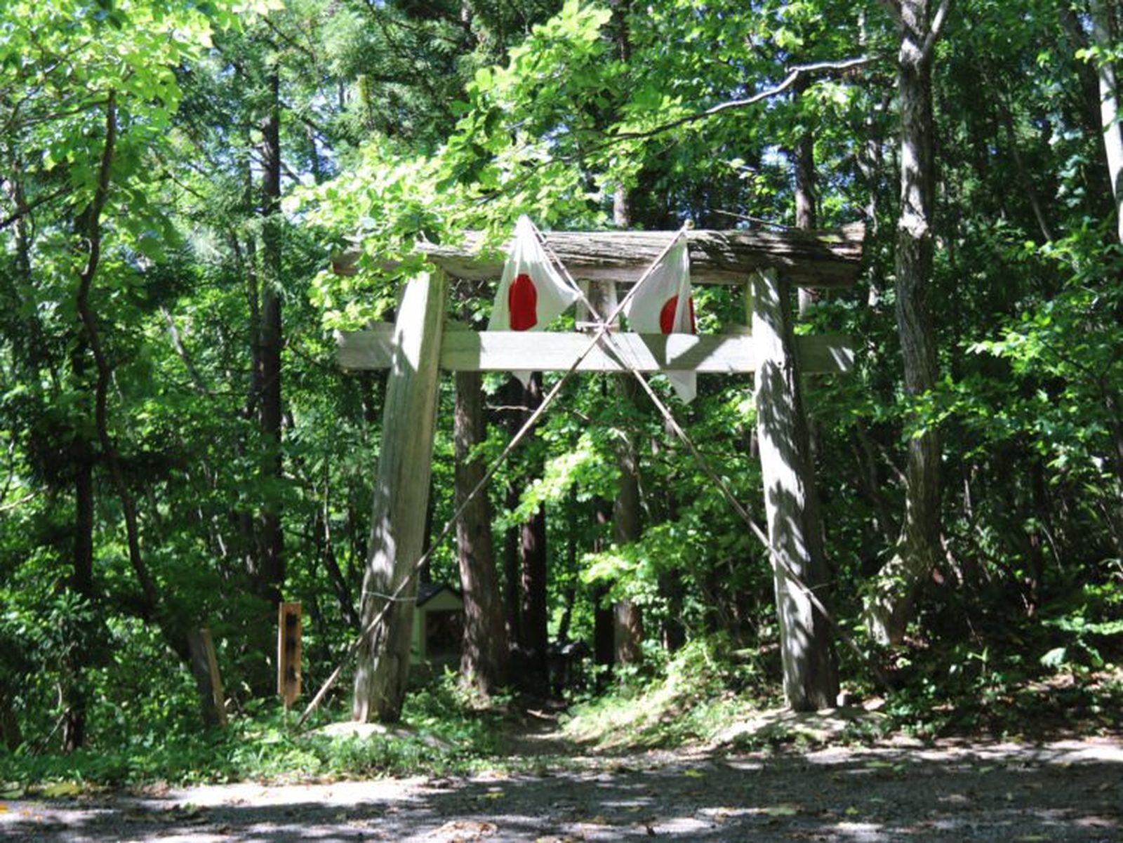 森の中に立つ石神神社の鳥居としめ縄