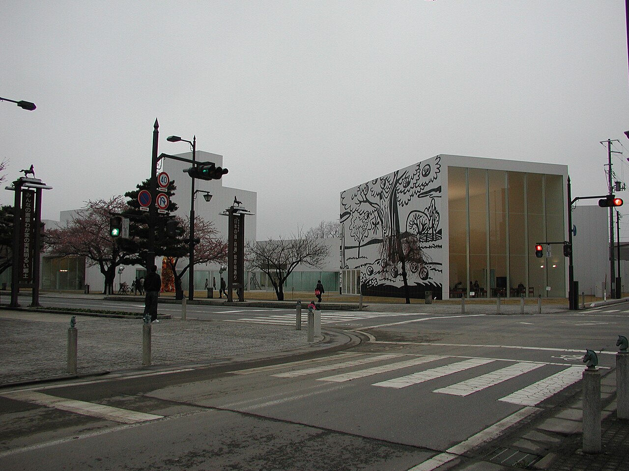 官庁街通りの交差点から見た十和田市現代美術館の白い展示棟と壁面の線画