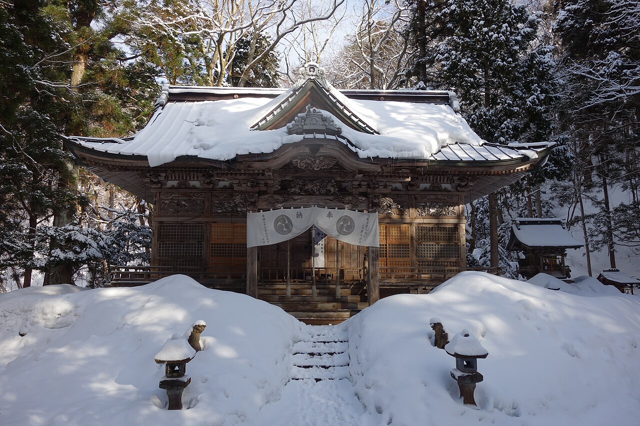 雪化粧した十和田神社の拝殿を石段の正面から見た様子