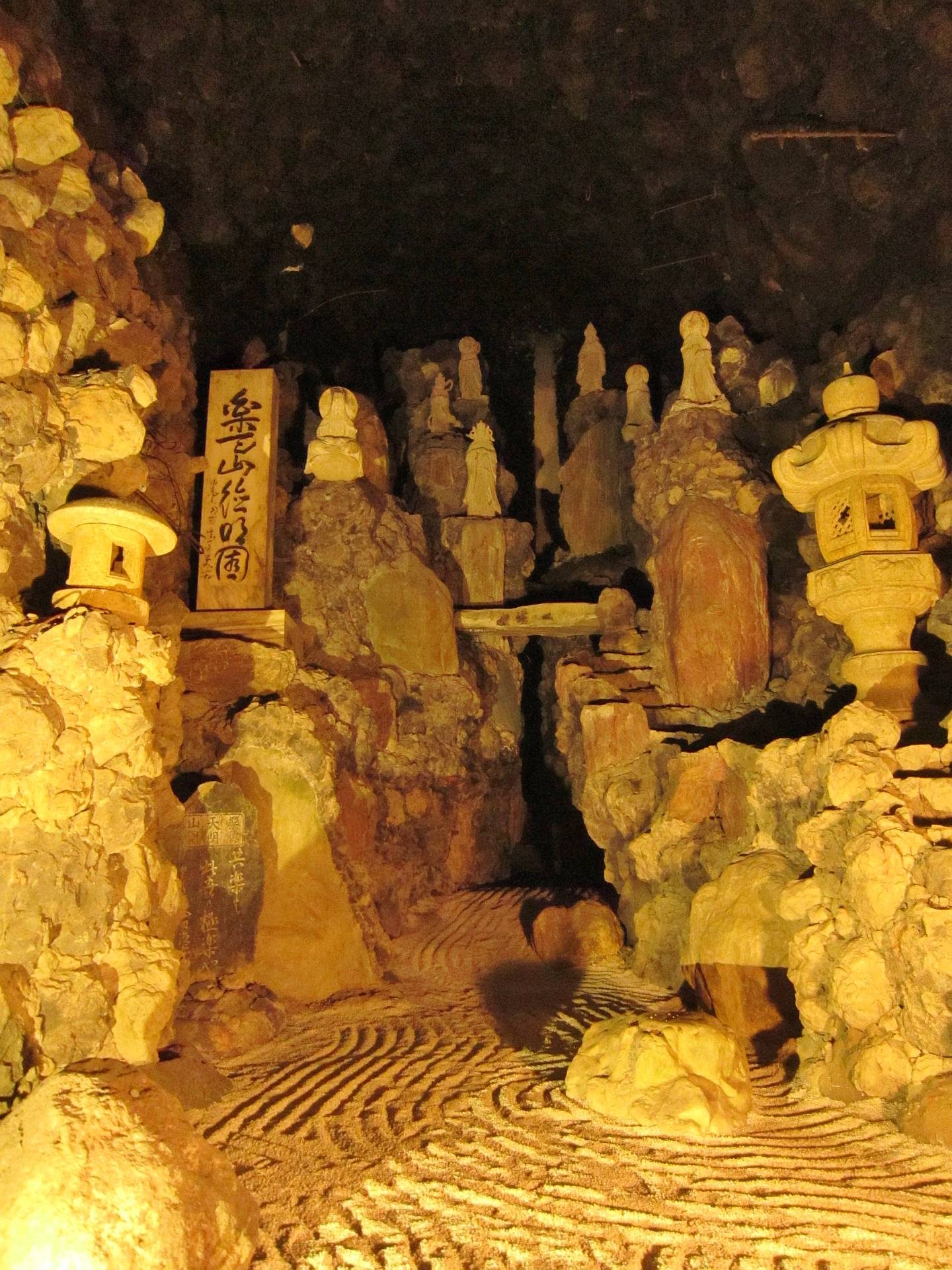 洞窟観音内部にずらりと並ぶ石造りの観音像群、石工・楽山の銘板