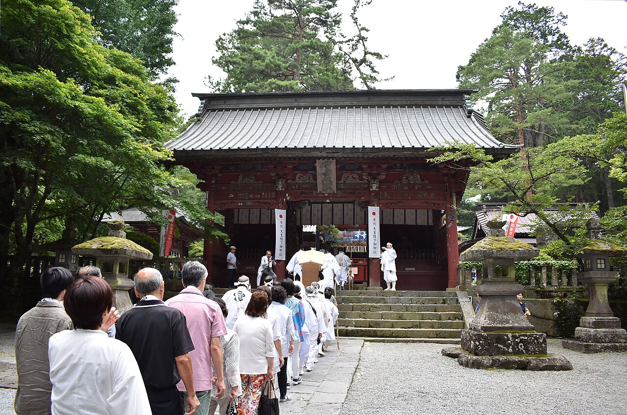 北口本宮冨士浅間神社の随神門と社殿に集う人々