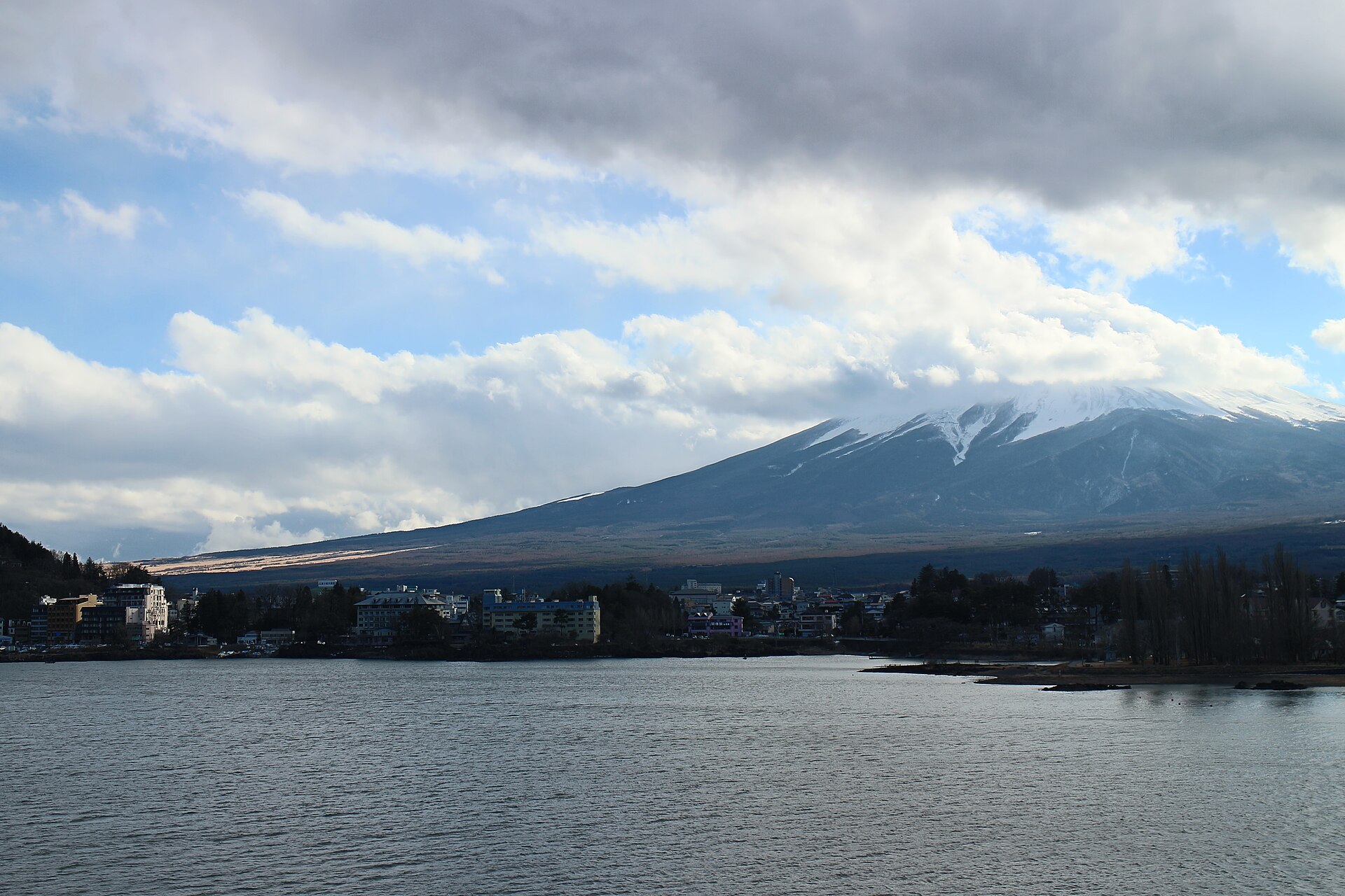 河口湖畔の街並みと雲をまとう富士山