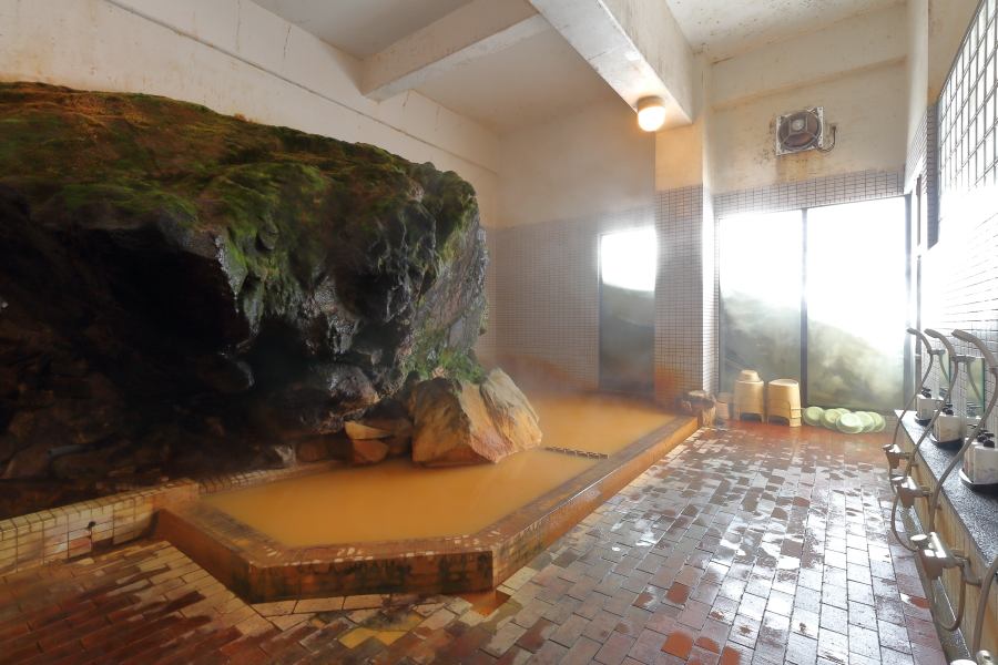湯元凌雲閣の内湯、岩を配した茶褐色の湯船