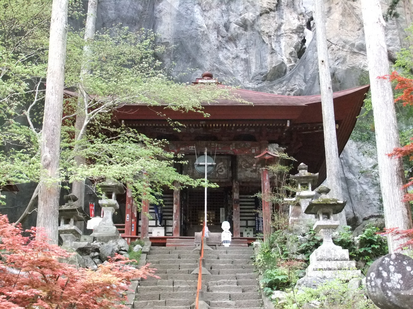 新緑と紅葉に彩られた橋立堂の石段、背後にそびえる石灰岩の大岩壁