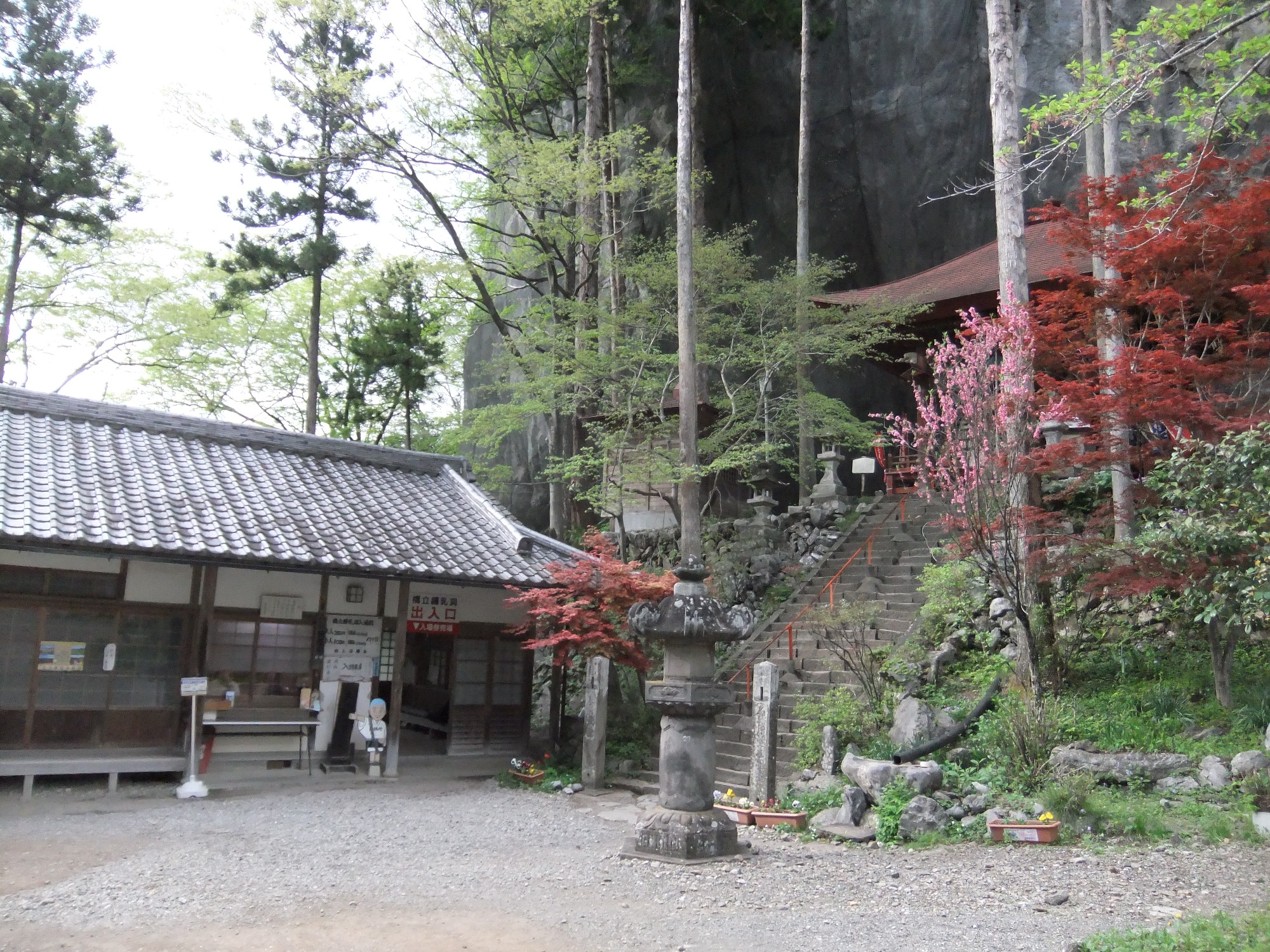 橋立鍾乳洞の入口と札所28番橋立堂、背後にそびえる石灰岩の大岩壁