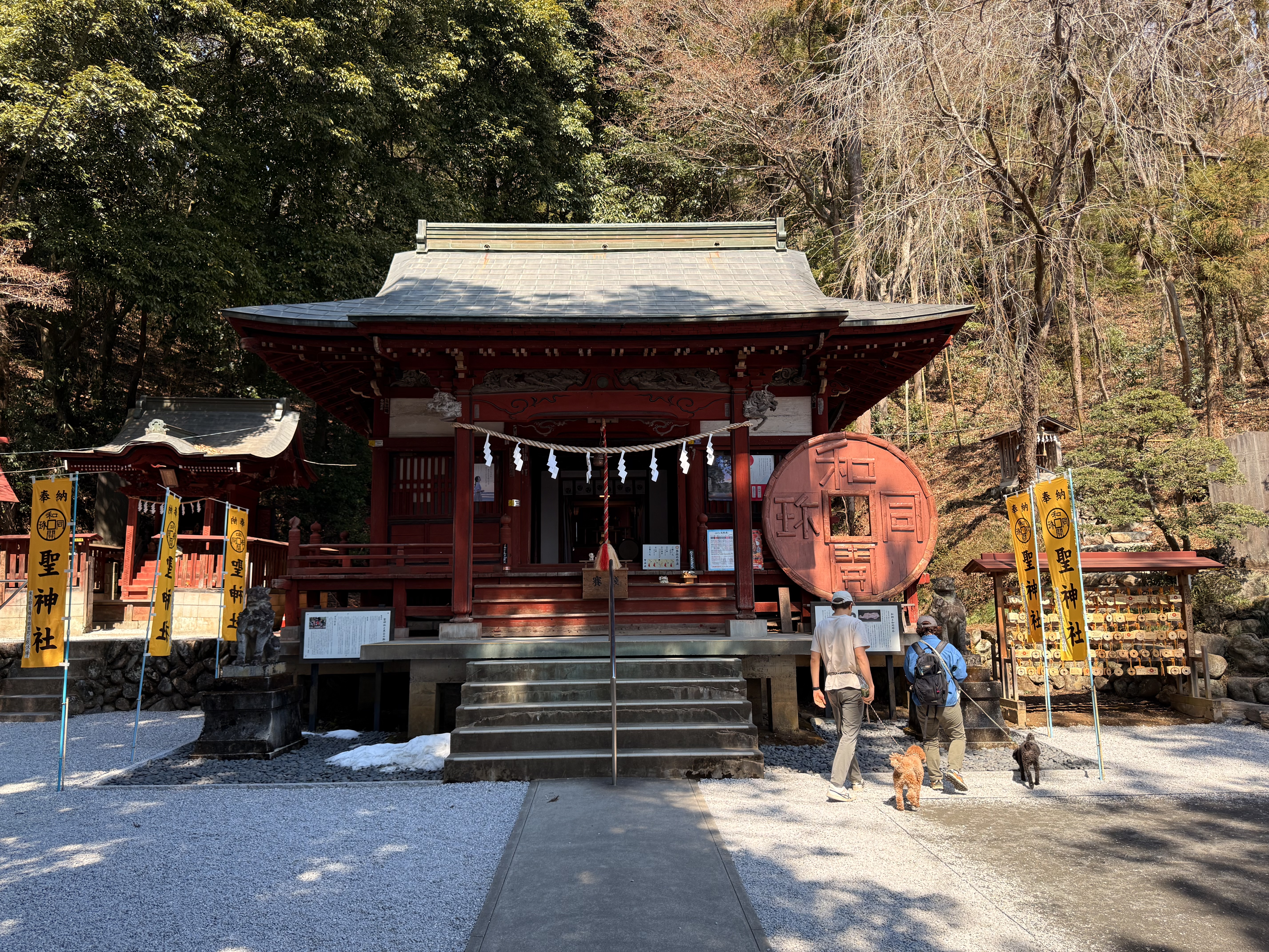 聖神社の拝殿を正面から見た様子、脇に和同開珎のモニュメントが立つ