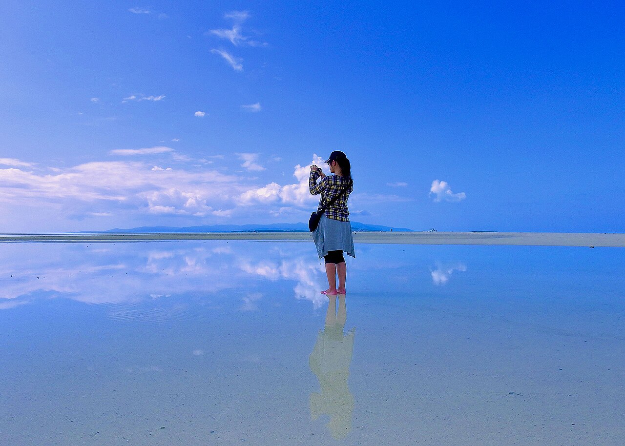 干潮時に現れる砂州の上に立つ旅人