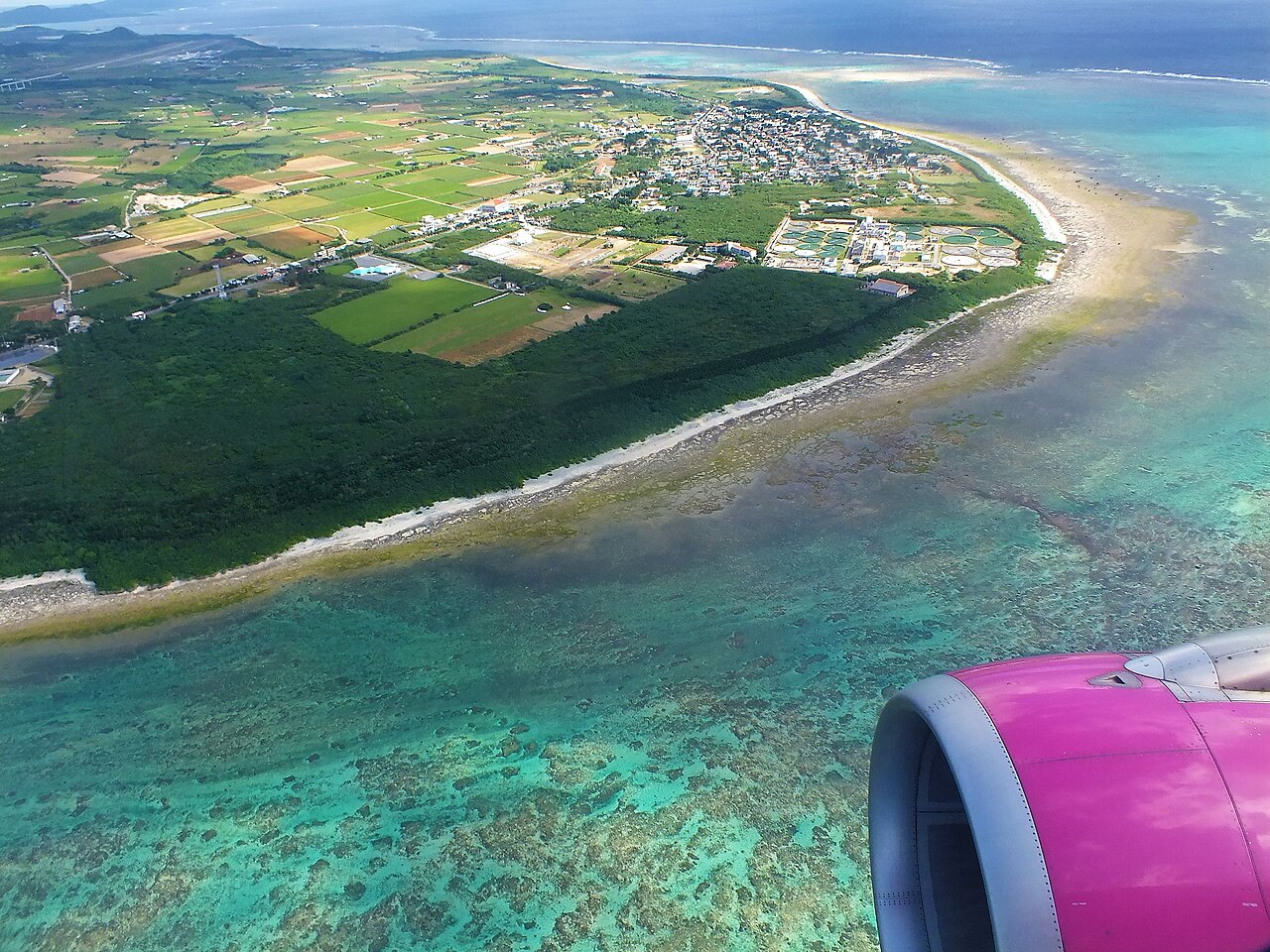 飛行機の窓から見た白保海岸周辺のサンゴ礁と集落