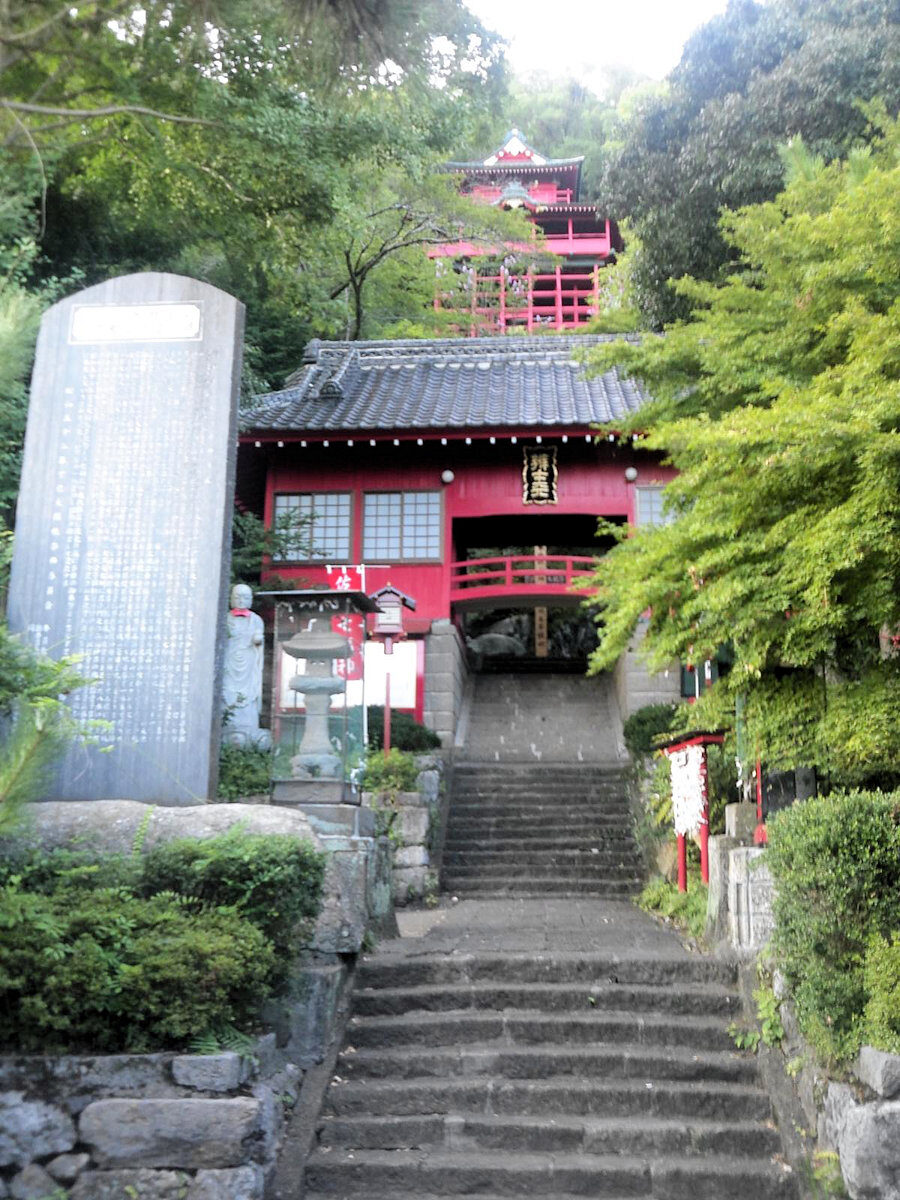 崖に張り付くように建つ磯山弁財天の懸造りの社殿と参道の石段