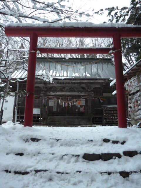 雪化粧した磐椅神社の朱塗りの鳥居と社殿