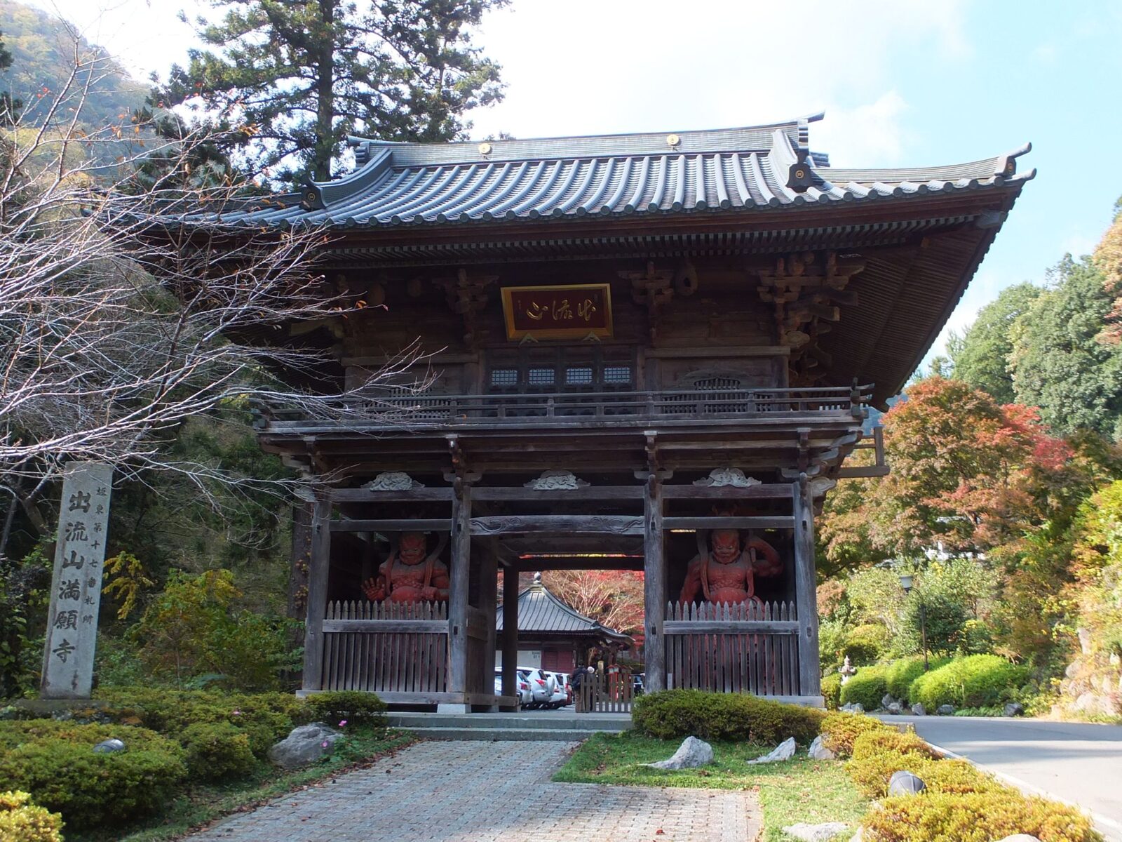 出流山満願寺の山門と仁王尊像、紅葉の参道