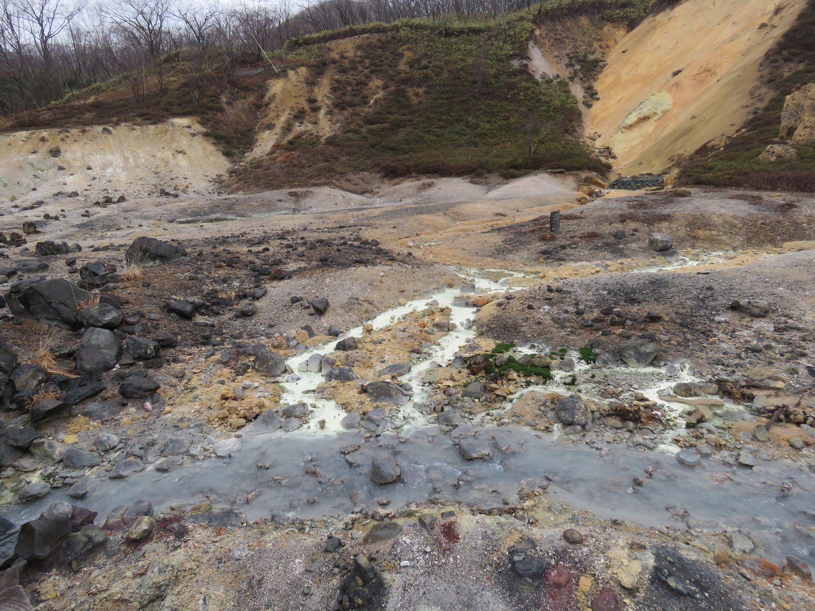 登別地獄谷を流れる硫黄成分を含んだ乳白色の温泉水の小川