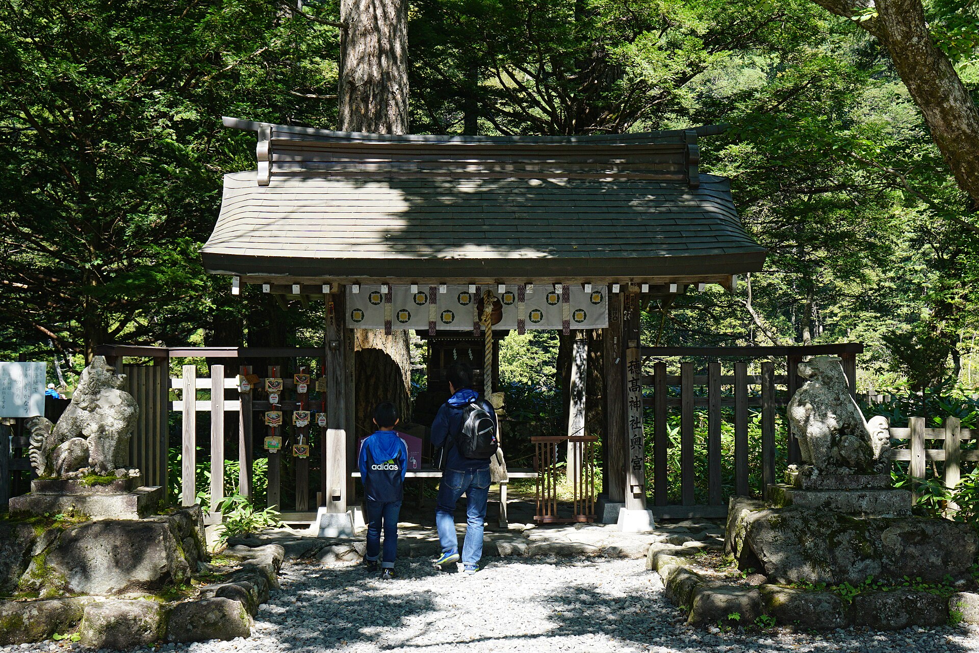 穂高神社奥宮の門と参拝する人の後ろ姿