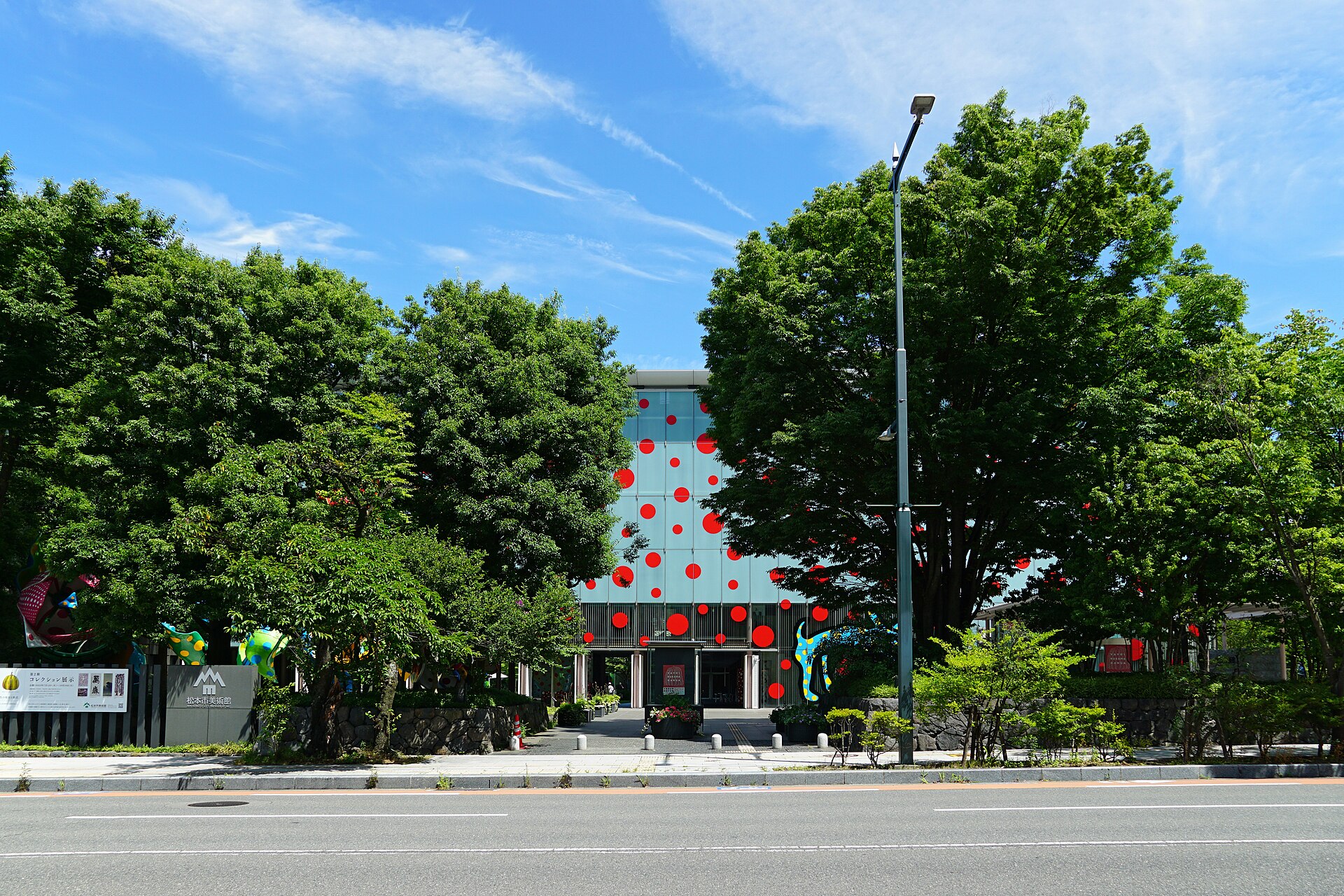 通りから見た松本市美術館の外観と草間彌生の野外作品