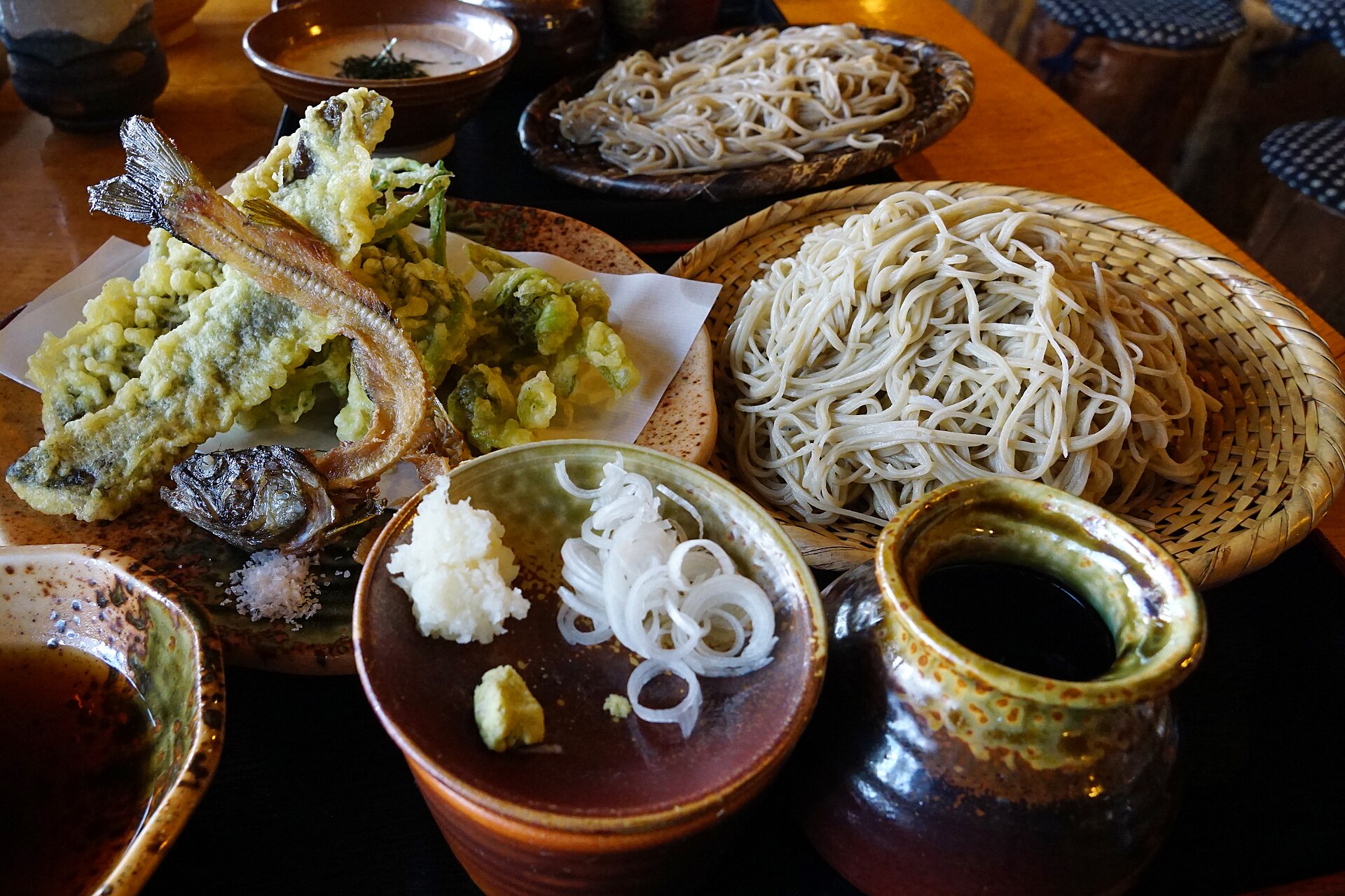 ざるに盛られた信州そばと山菜の天ぷら、岩魚の塩焼き