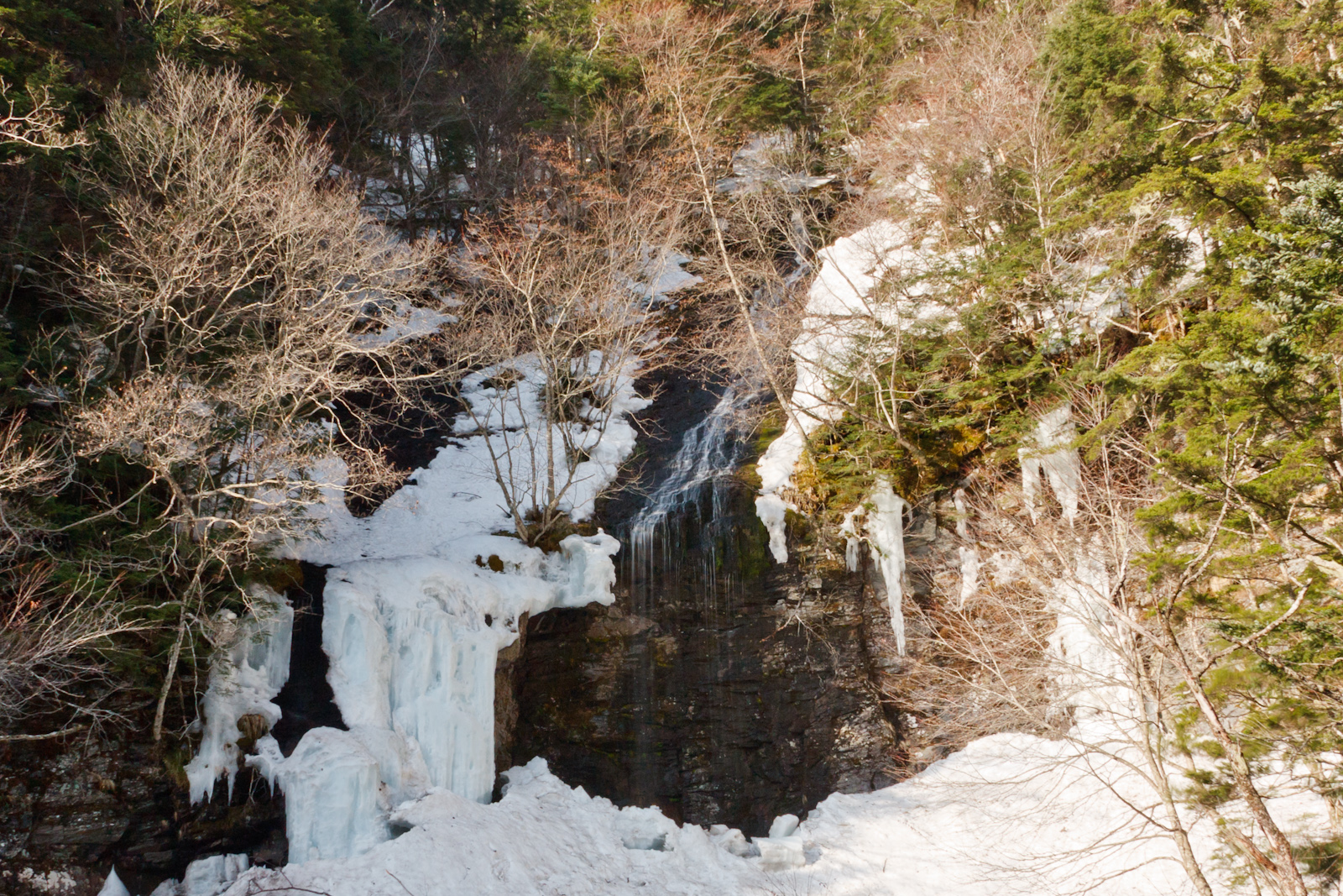 残雪と氷に覆われた三本滝の無名沢の流れ