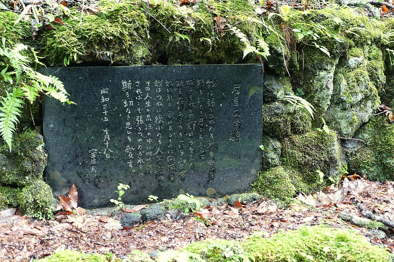 苔むした石積みを背に立つ室生犀星文学碑。昭和三十五年建立の刻銘が読める