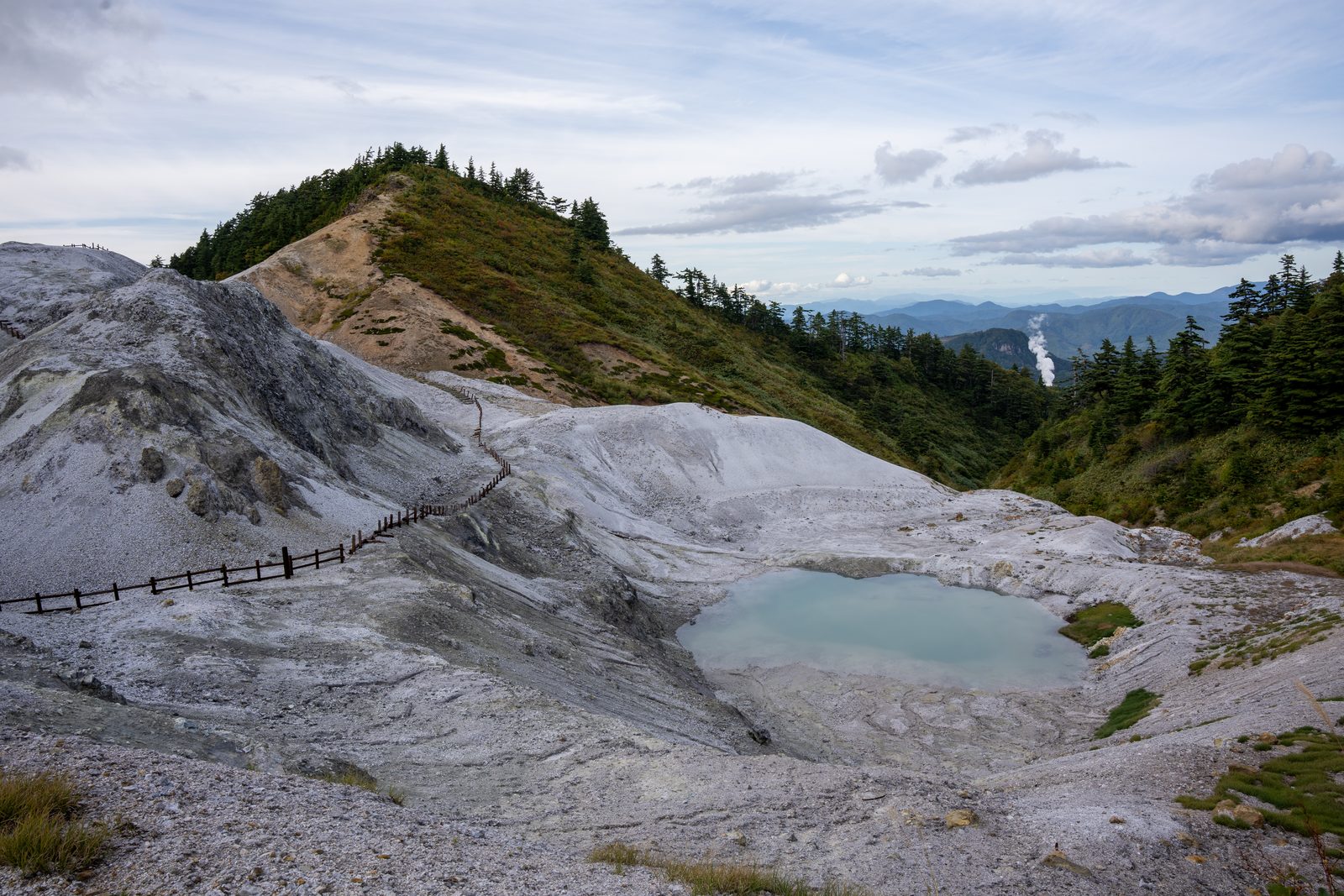 灰白色の山肌のあちこちから噴気が立ちのぼる川原毛地獄