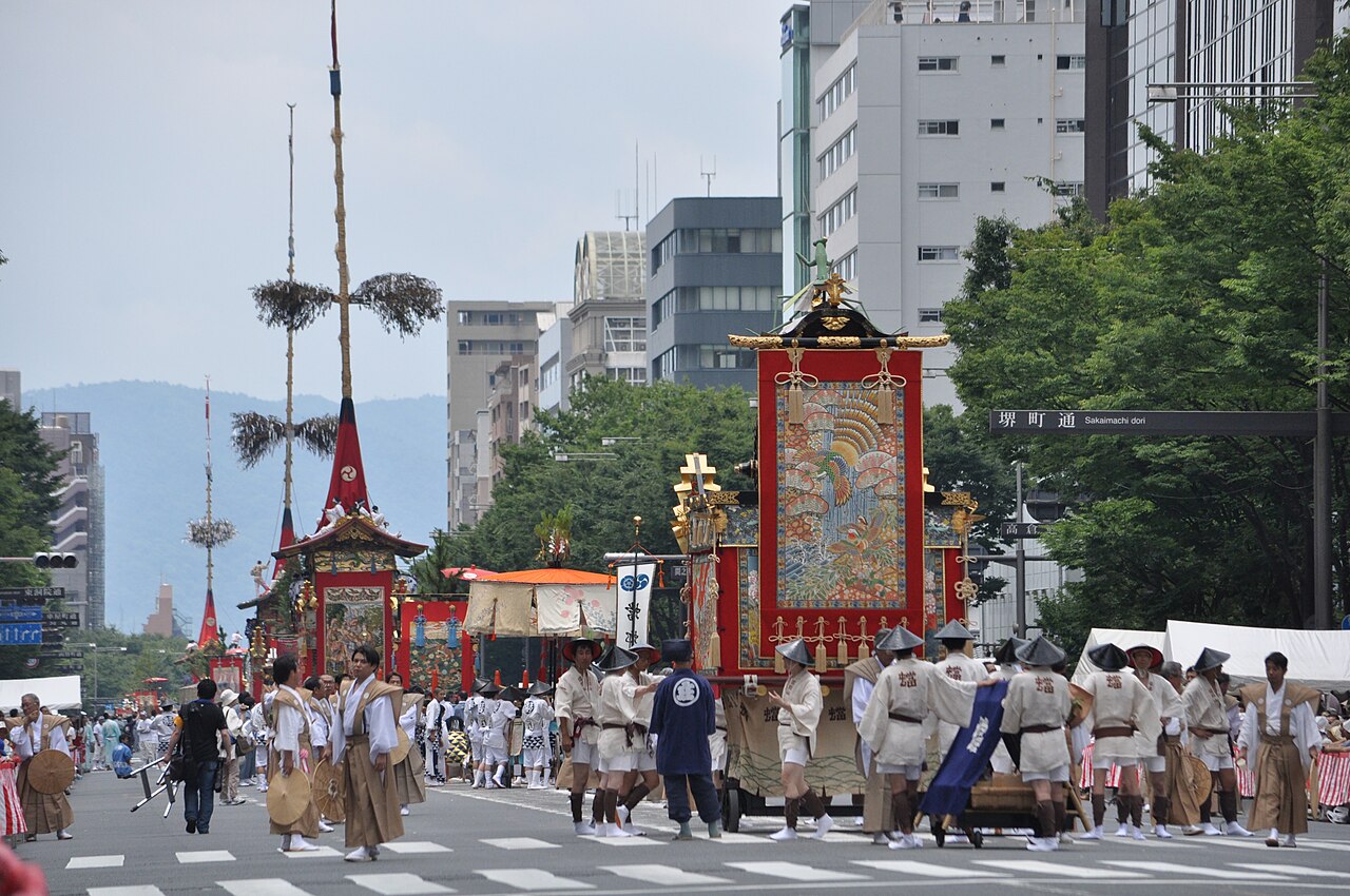 祇園祭の鉾に掛けられた懸装品と、進行を待つ曳き手たち
