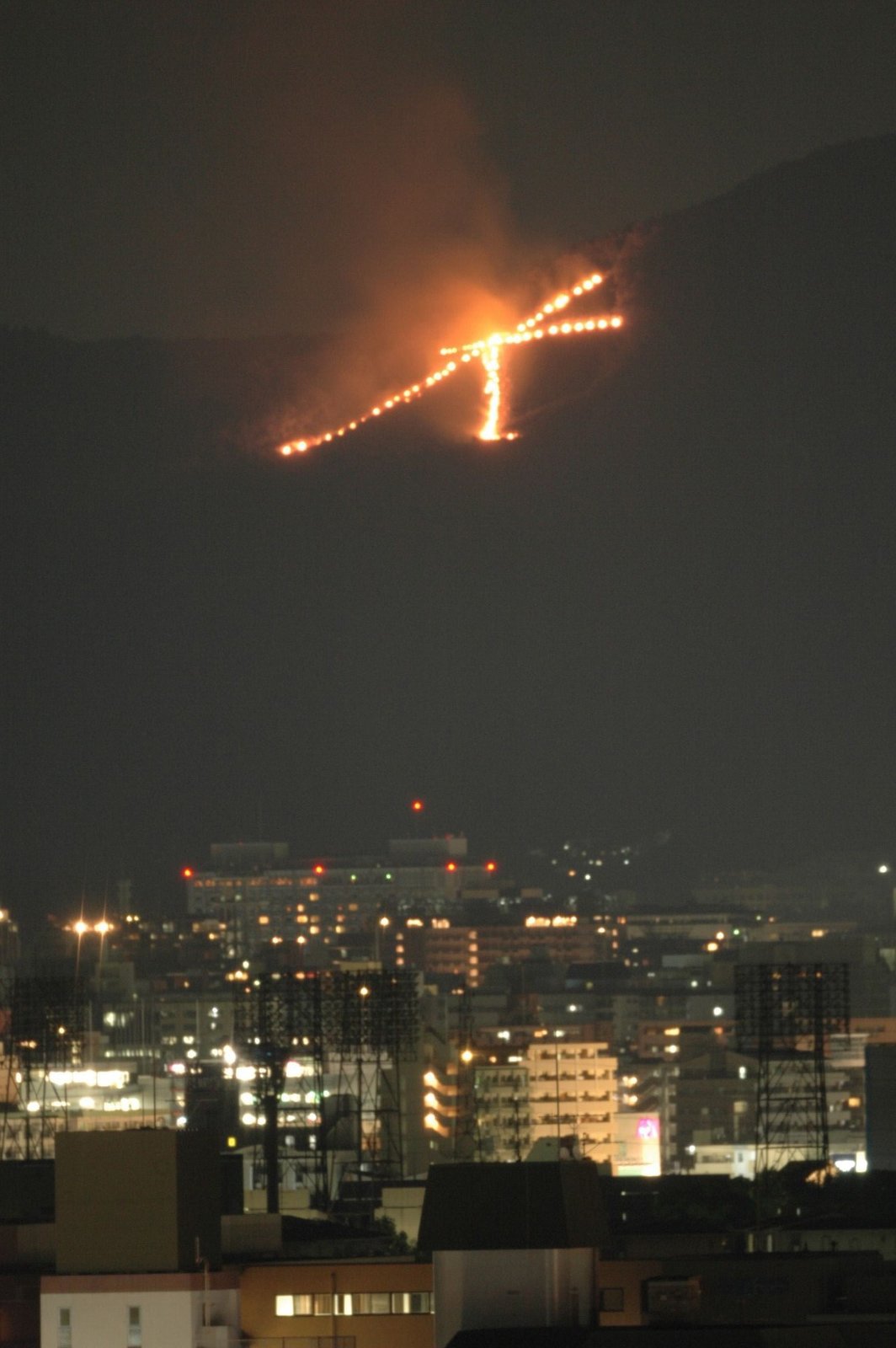 京都市街の夜景の上に浮かび上がる大文字の送り火