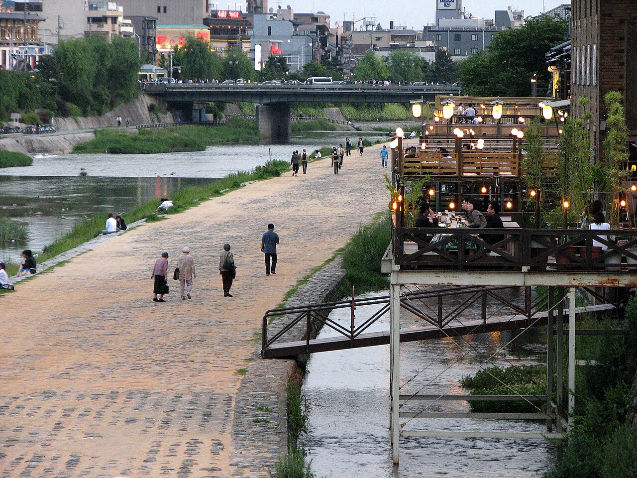 三条大橋から見た夕暮れの鴨川と、灯りのともった納涼床