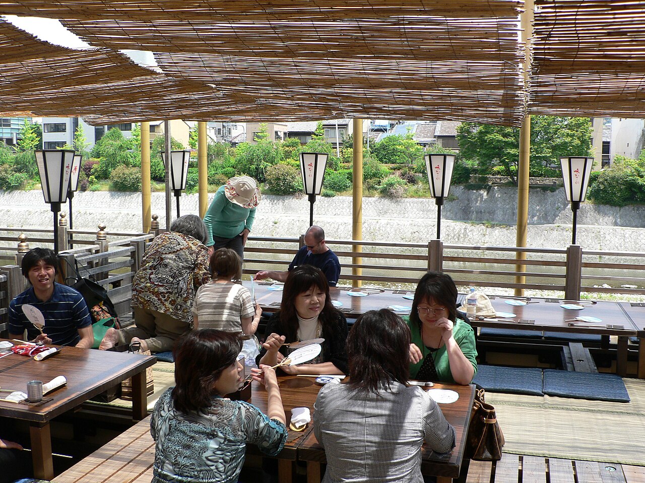 夕暮れ、灯りがともる鴨川の納涼床