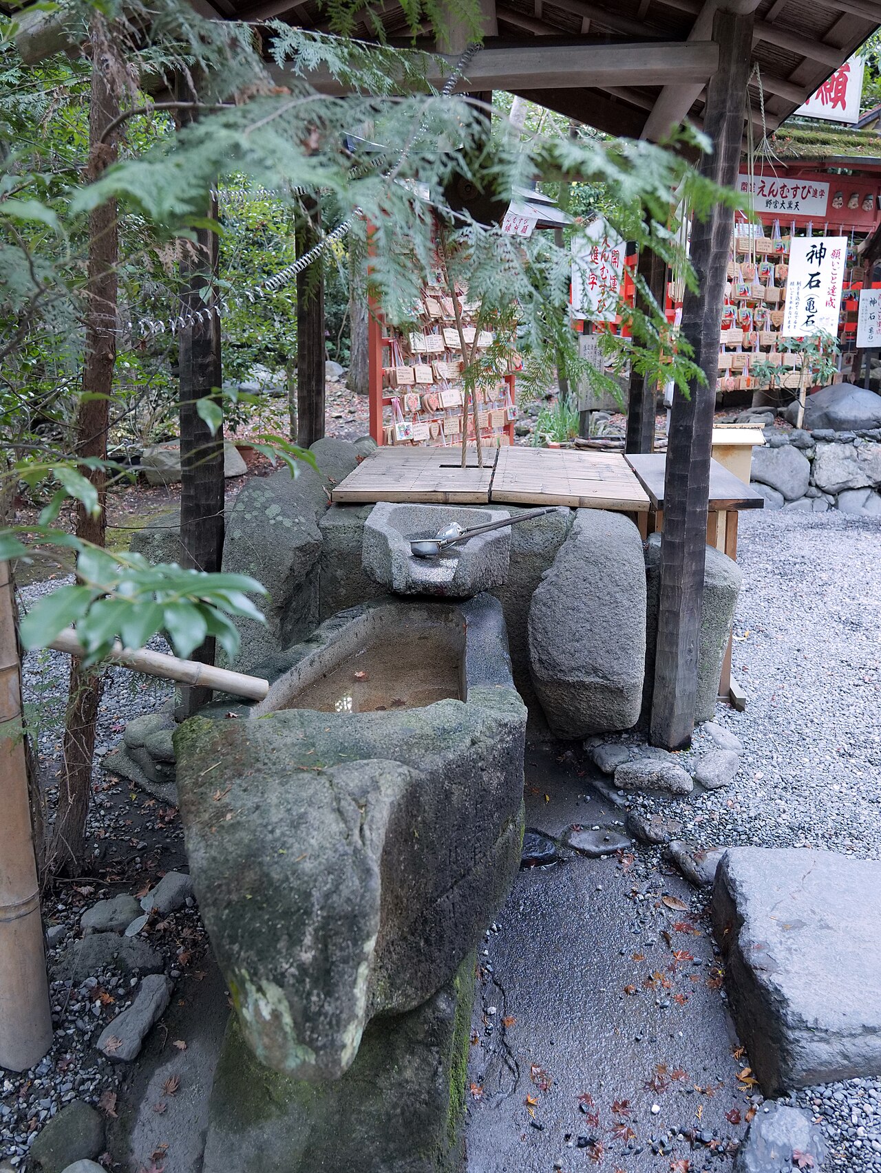 野宮神社の手水舎と、奥に並ぶ絵馬と神石亀石