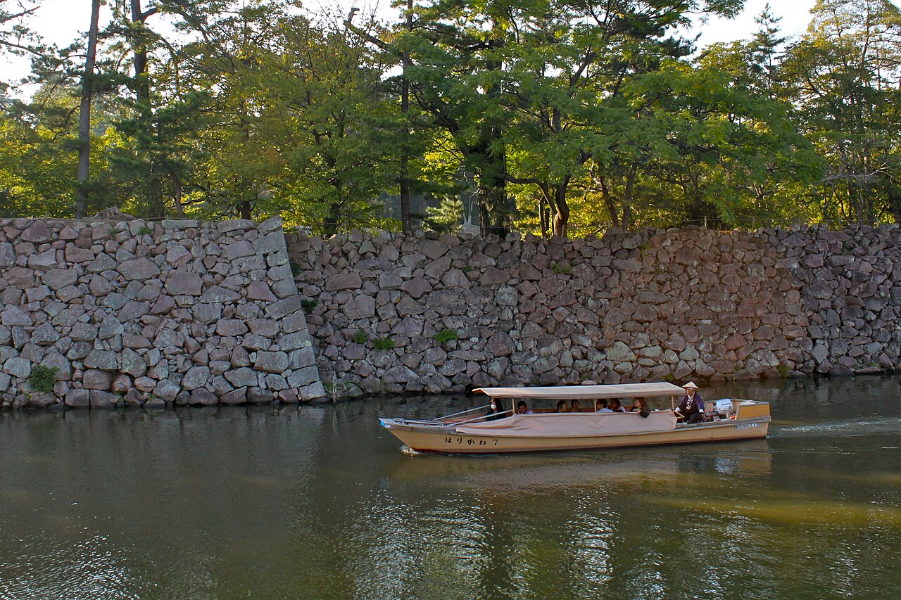 石垣沿いを進む堀川めぐりの屋根舟