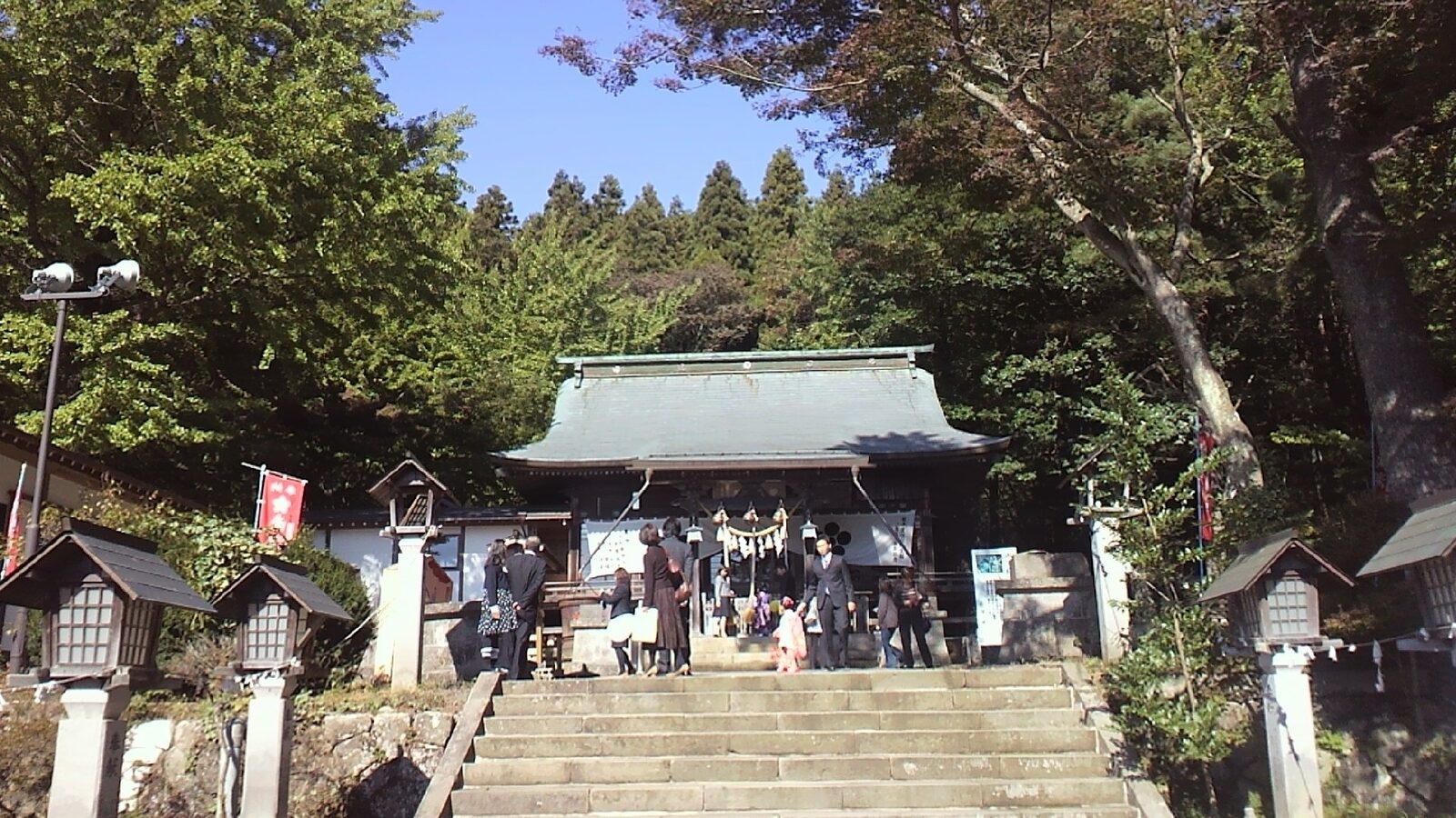 南湖神社の社殿と参道の石段、参拝者の様子