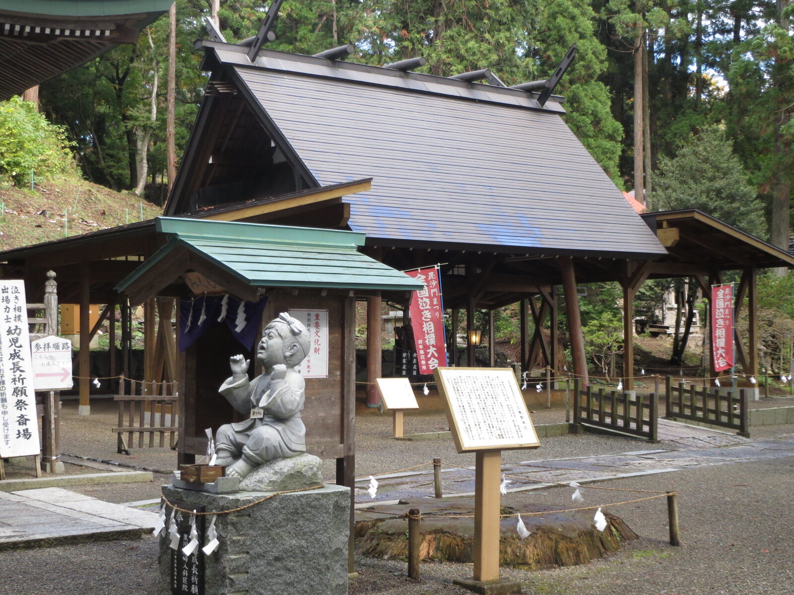 泣き相撲が奉納される境内の土俵と幼児成長祈願の像