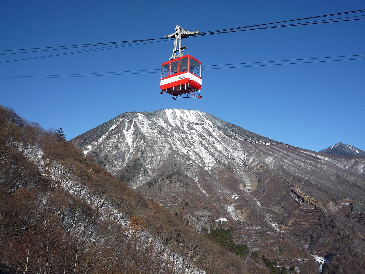 明智平ロープウェイの赤いゴンドラと、雪をまとった男体山