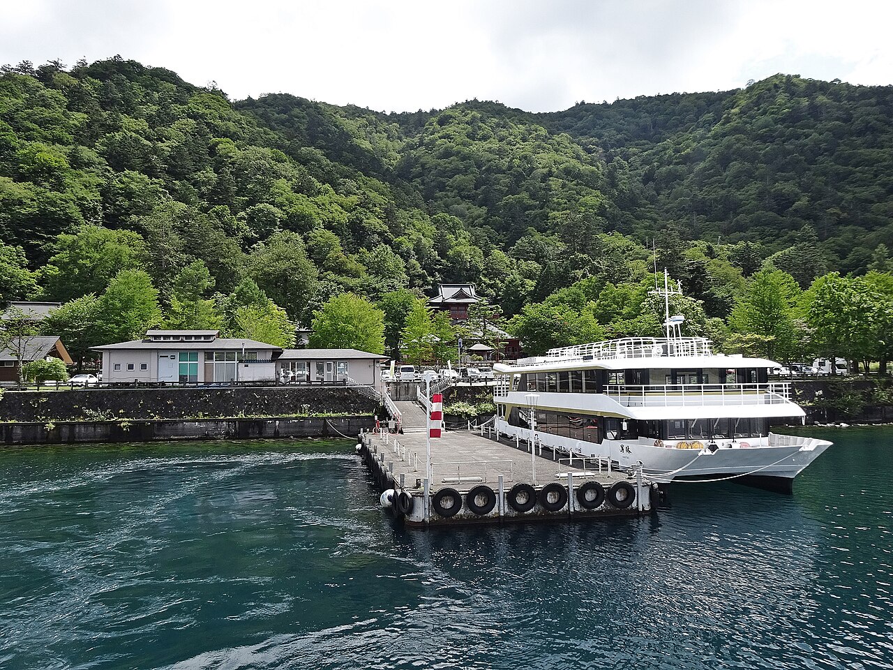 中禅寺湖の桟橋に停泊する遊覧船と新緑の山々