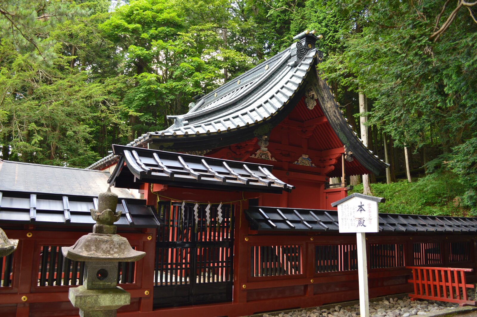 日光二荒山神社中宮祠の本殿。朱塗りの社殿と石灯籠