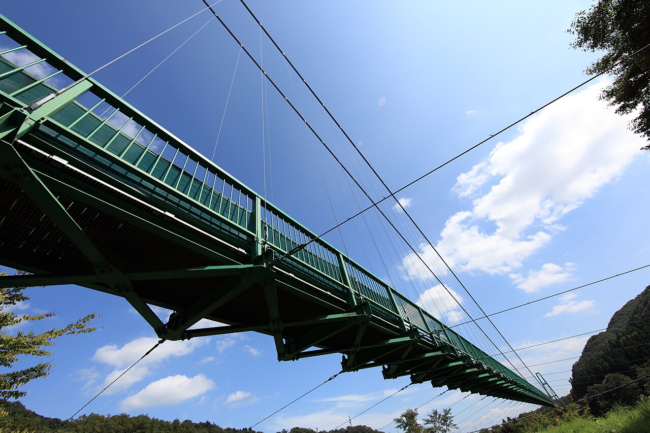 もみじ谷大吊橋を真下から見上げた全景。緑色の橋桁が空へ伸びる