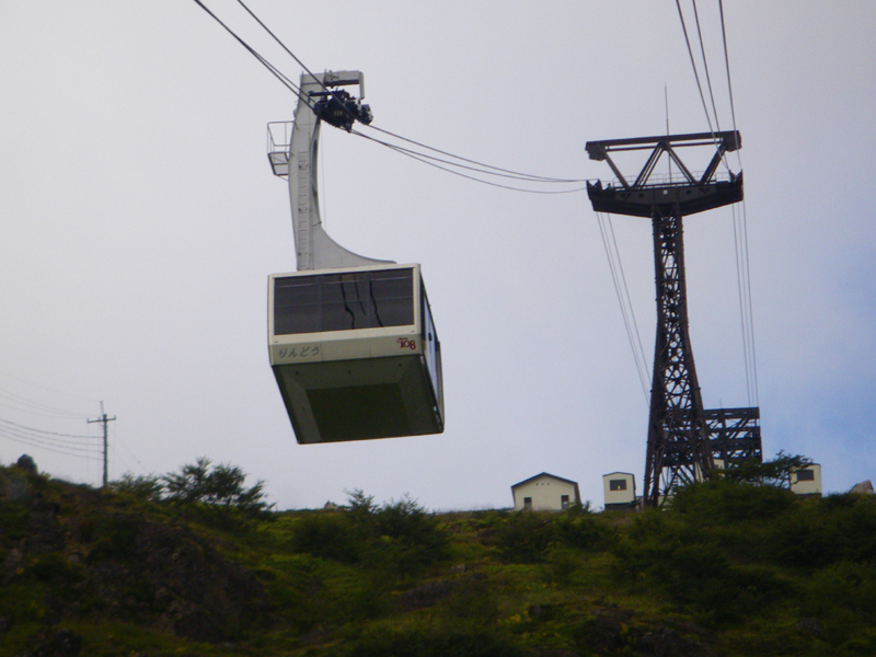 那須ロープウェイのゴンドラと支柱・奥に山頂駅の建物