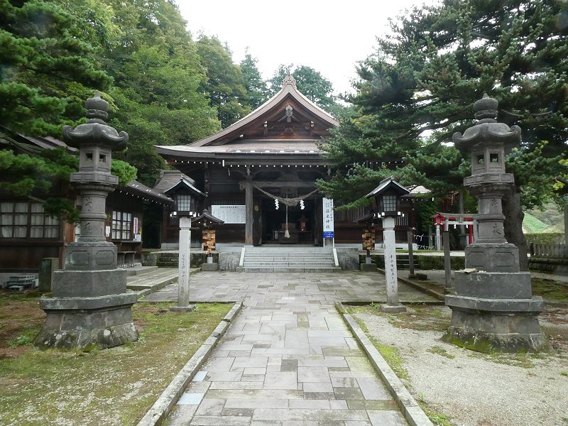 那須温泉神社の社殿と、参道に並ぶ石灯籠