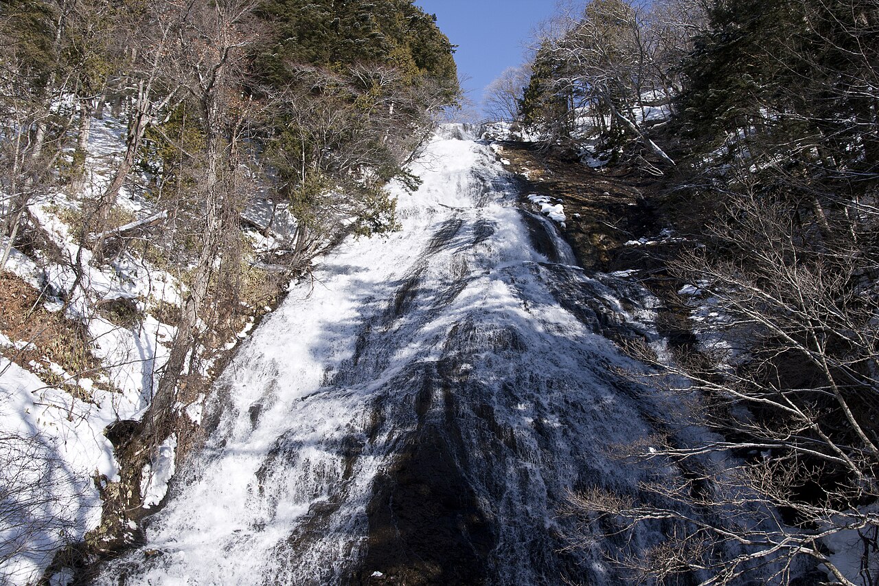 雪と氷に覆われた冬の湯滝を見上げる