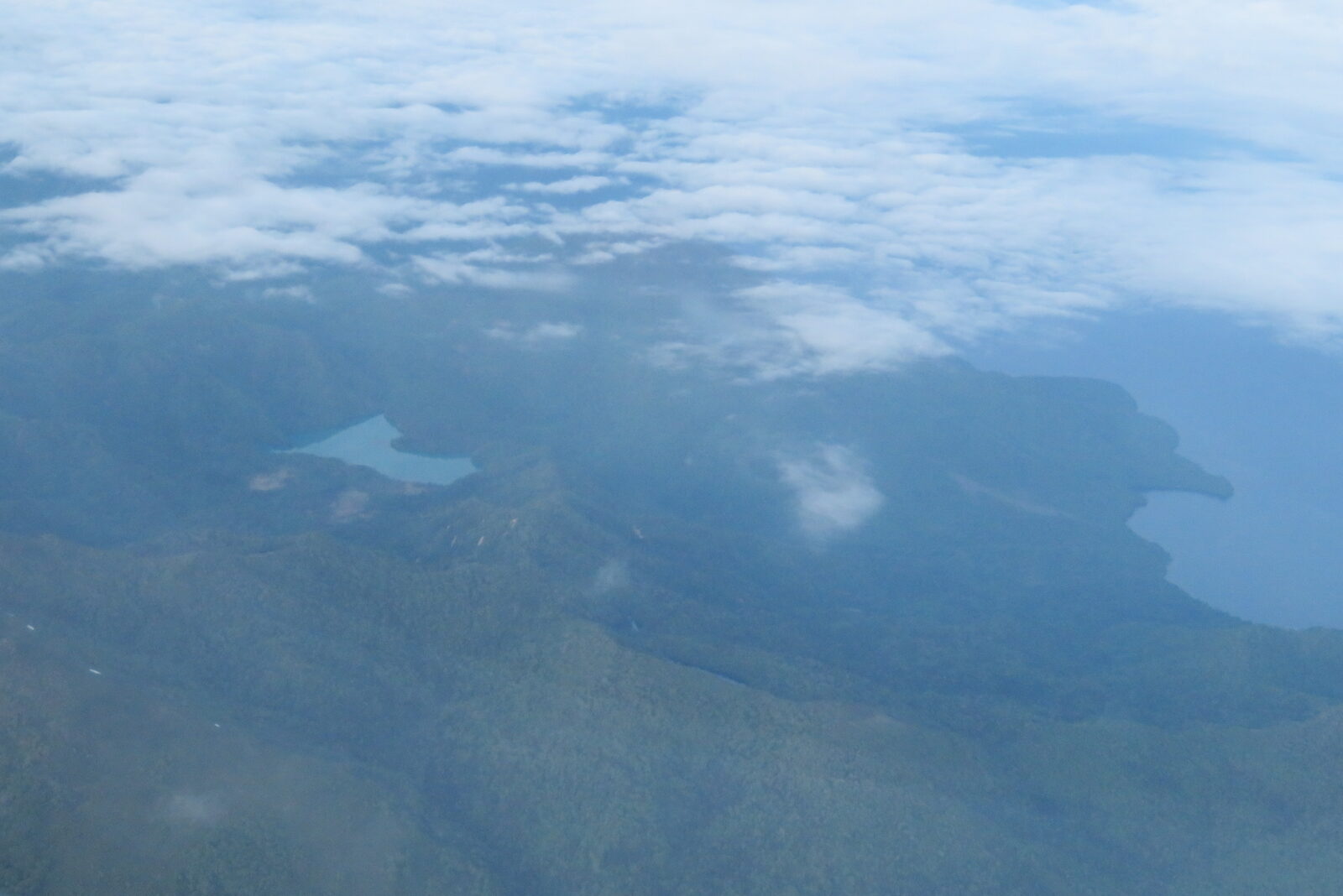 雲間から見えるオコタンペ湖と周辺の山並みの空撮風景
