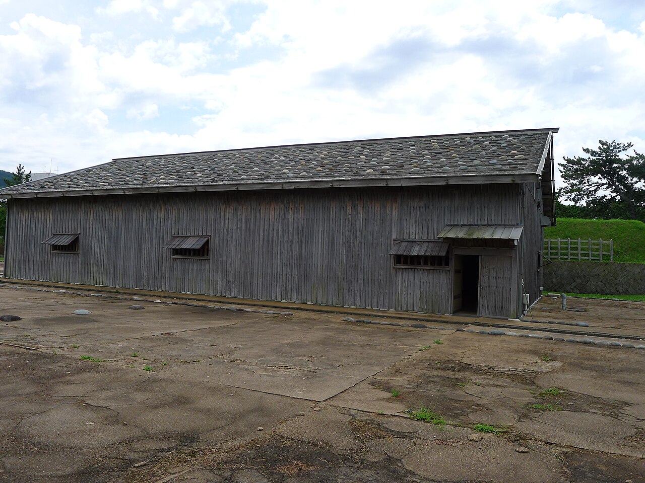 復元された勝場(せりば)の建物外観、玉石葺きの屋根