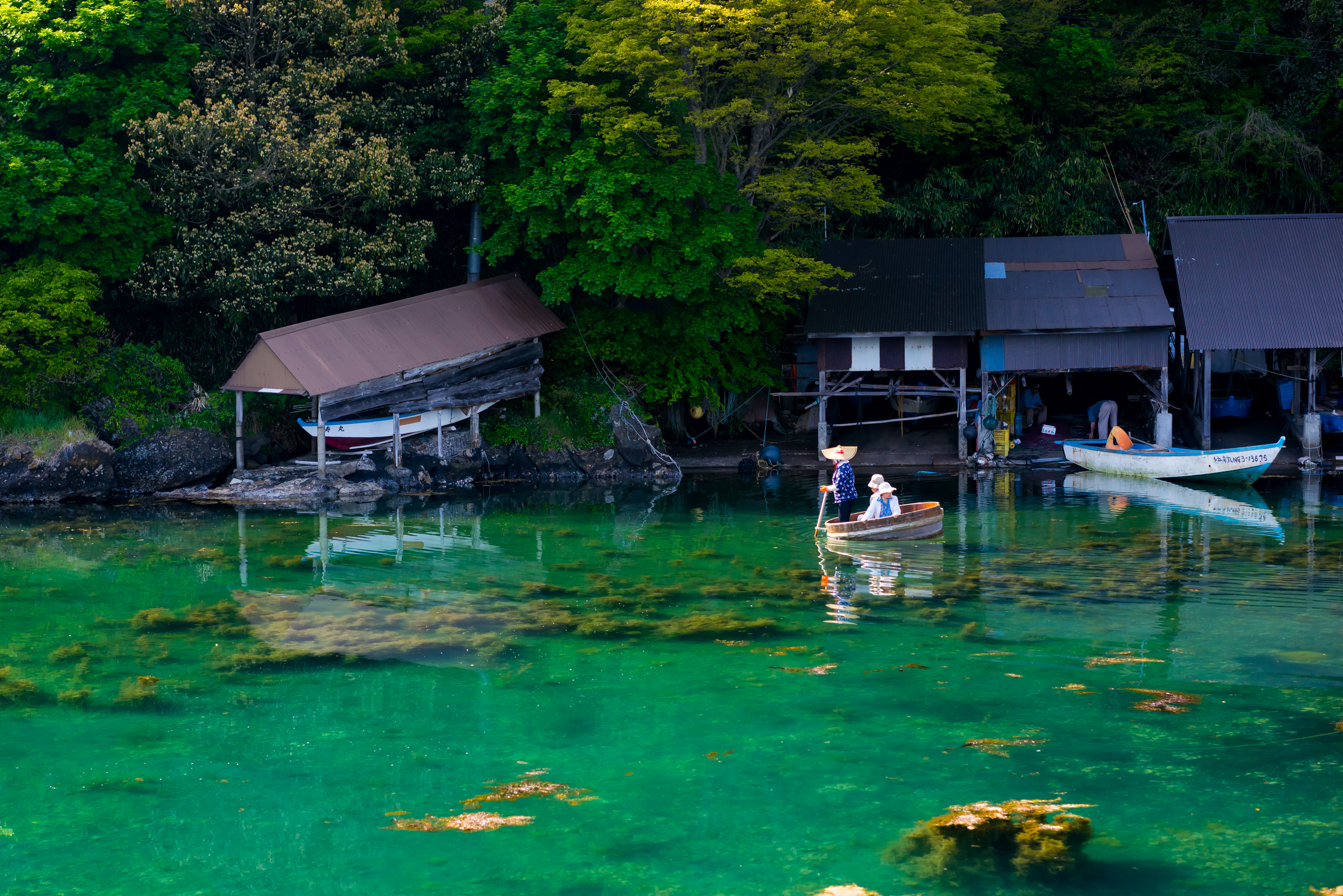 矢島の入り江に浮かぶたらい舟と、軒を連ねる舟小屋