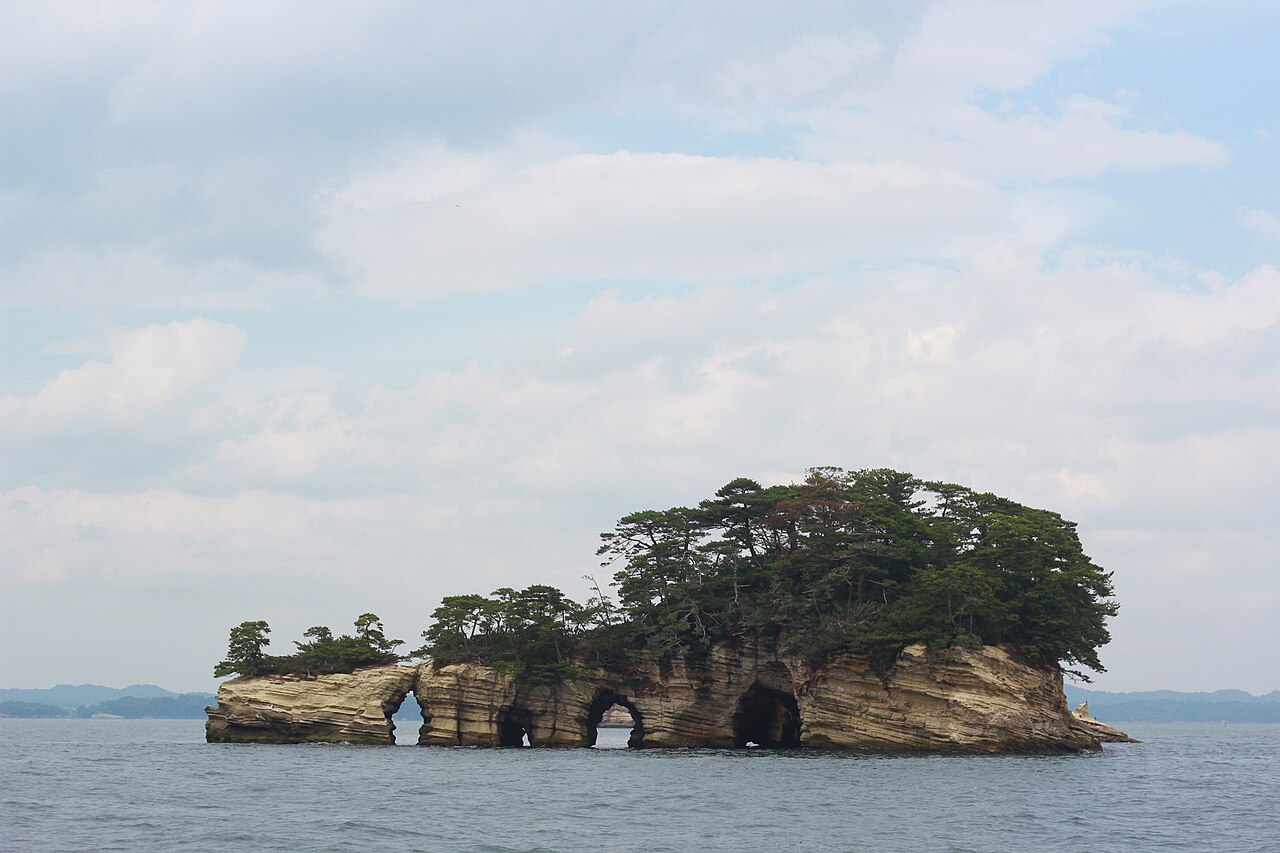 松の木が生い茂り、波の浸食でアーチ状の洞穴ができた奇岩の島