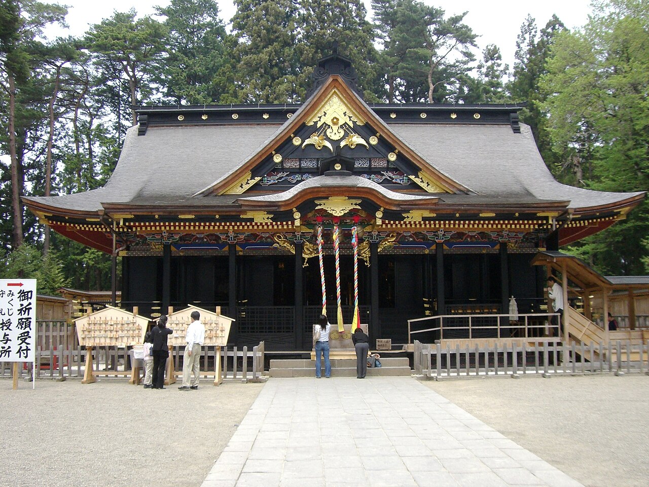 参拝者が国宝の社殿に手を合わせる大崎八幡宮の境内